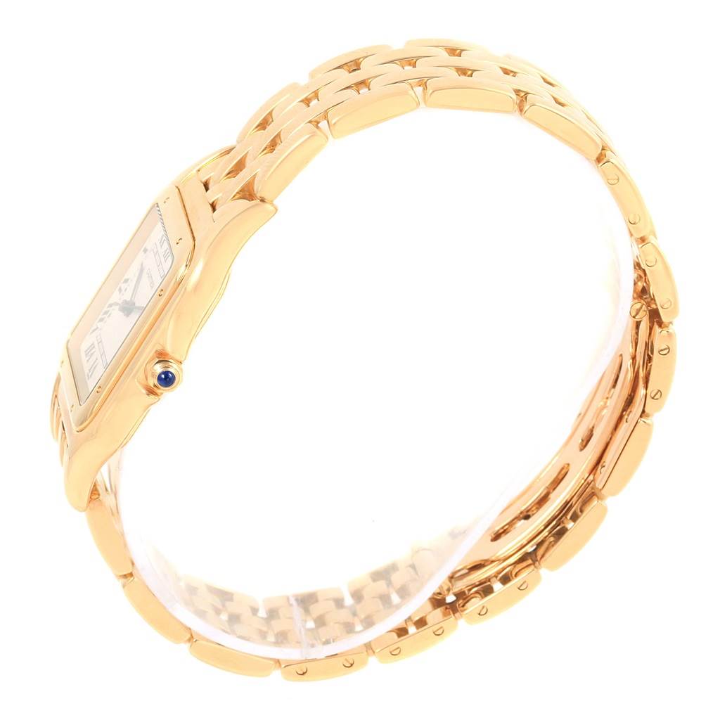 The Panthere model by Cartier is shown at an angle highlighting its gold bracelet, side of the case, and bezel with a blue cabochon crown.