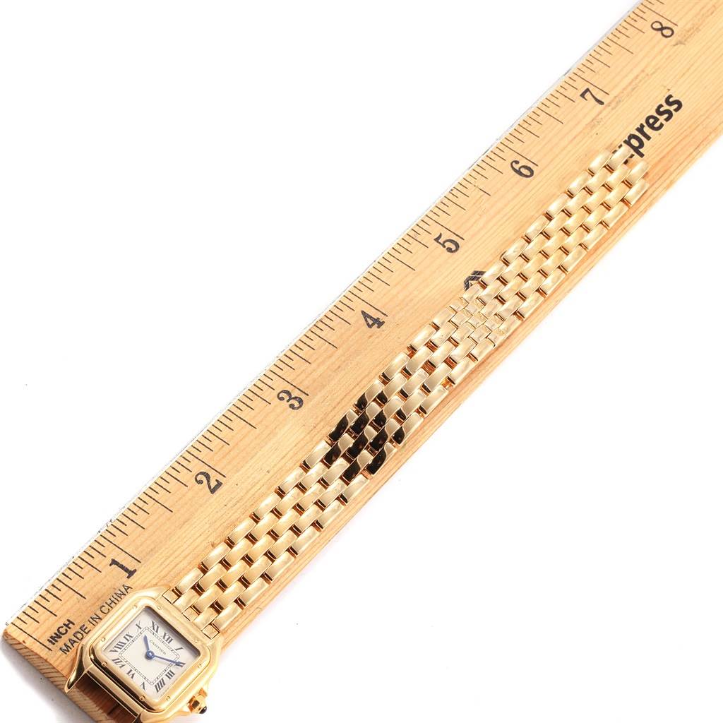 The image shows a gold Panthere model by Cartier, with the watch face and a portion of the bracelet next to a ruler for scale.