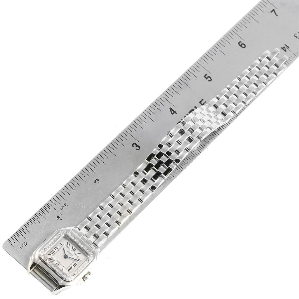 The image shows an overhead view of the Cartier Panthere WF3091F3 Women
s White Gold Silver Dial WF3091F3 Women
s White Gold Silver Dial watch alongside a ruler for scale.