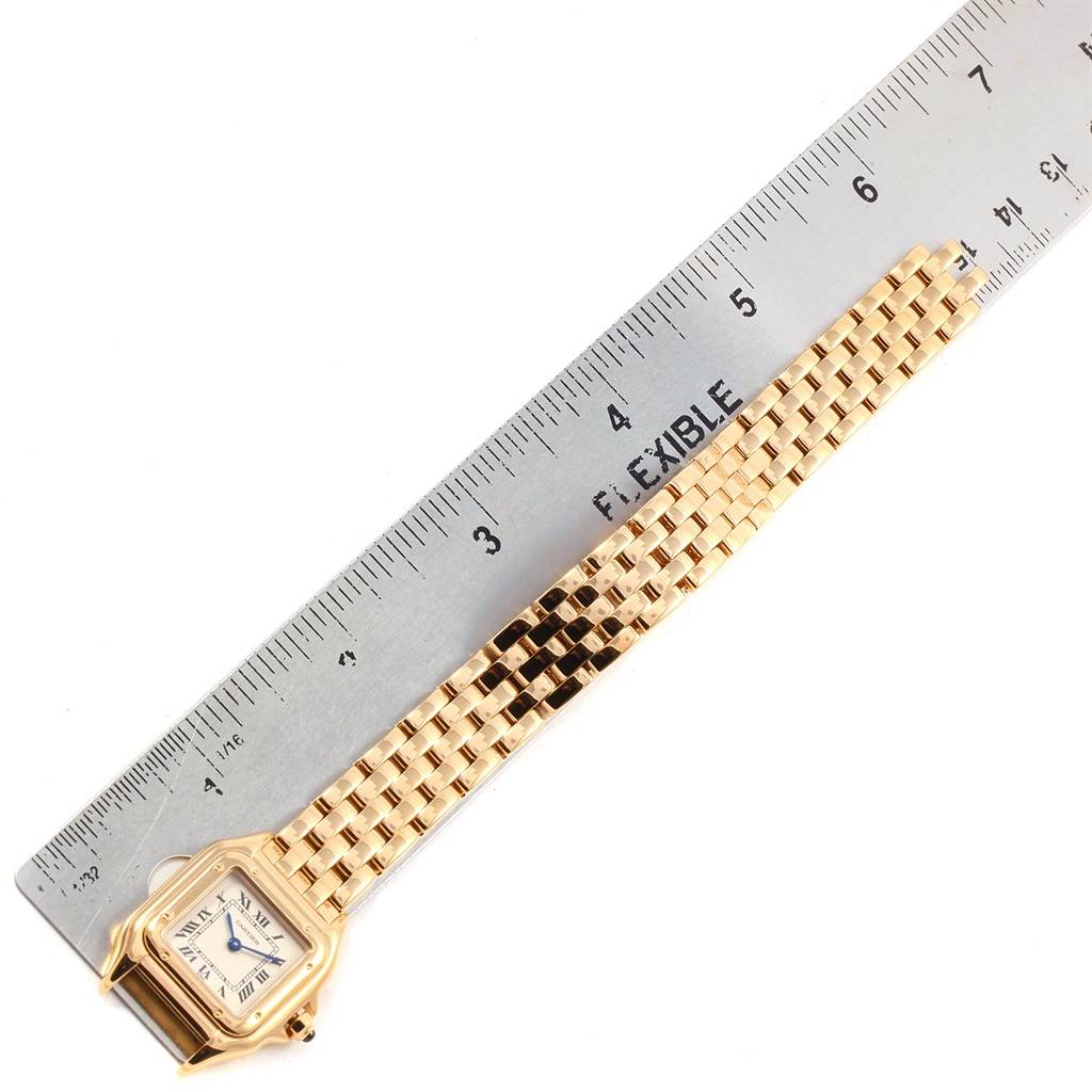 The image shows a Cartier Panthere W25022B9 Women's Yellow Gold Silver Dial W25022B9 Women's Yellow Gold Silver Dial watch laid next to a ruler, highlighting the face and bracelet in a side angle view.