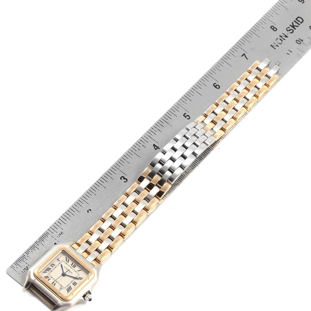 The Panthere model by Cartier watch is shown from a top-down angle, highlighting the face and bi-metal bracelet next to a ruler.