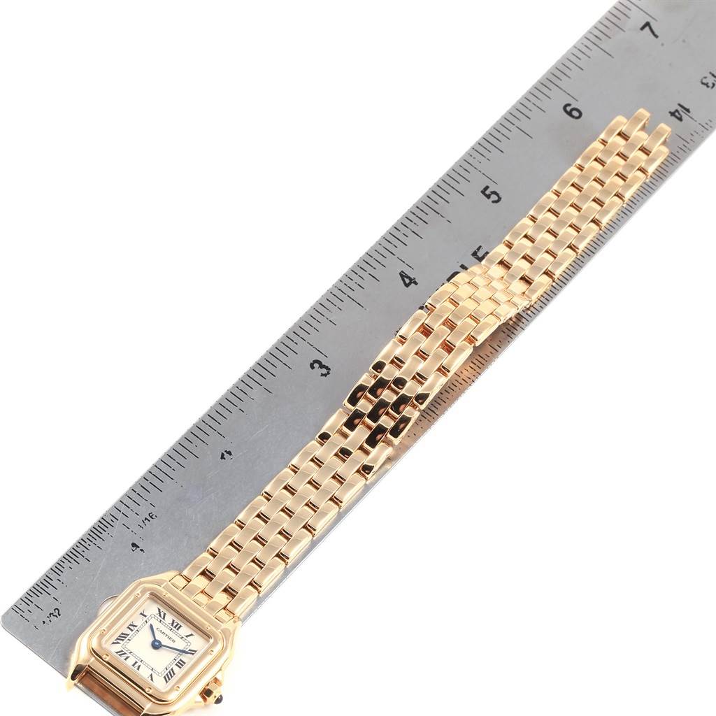 The image shows an overhead view of the Cartier Panthere W25022B9 Women's Yellow Gold Silver Dial W25022B9 Women's Yellow Gold Silver Dial watch laid next to a ruler, highlighting its band and case.