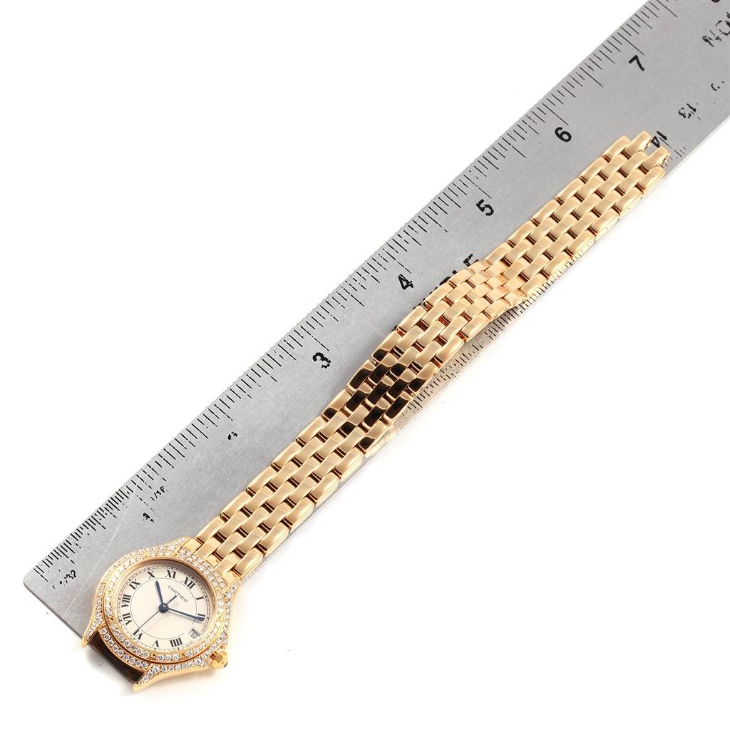 The Cartier Panthere 887907 Yellow Gold Silver Dial 887907 Yellow Gold Silver Dial watch is shown from a top-down angle, featuring its face and bracelet alongside a measuring scale.