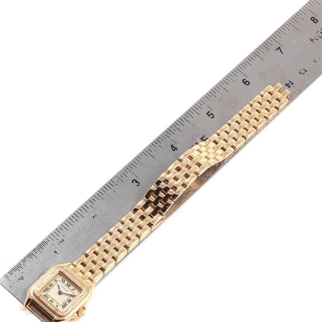 The image shows the Cartier Panthere WF3070B9 Women's Yellow Gold Beige Dial WF3070B9 Women's Yellow Gold Beige Dial watch with its gold bracelet measured alongside a ruler.