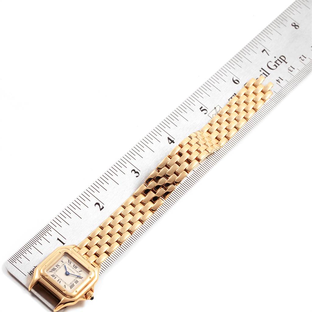 The image shows a Panthere model watch by Cartier placed next to a ruler, showcasing its face and bracelet.