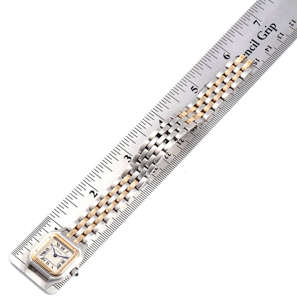 The Panthere model by Cartier is shown at a top-down angle, featuring its face and partially extended two-tone band against a ruler.
