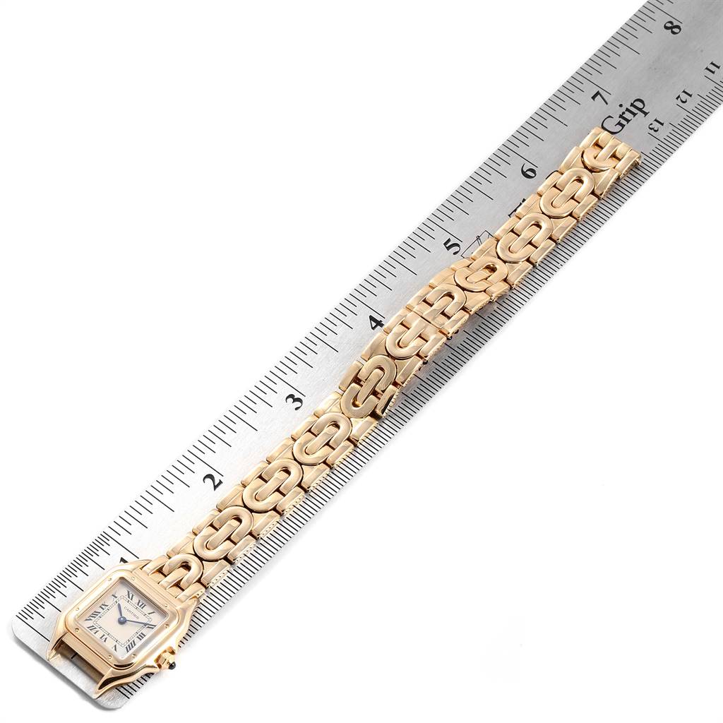 The Panthère de Cartier watch is shown at an angle with its bracelet fully extended alongside a ruler.