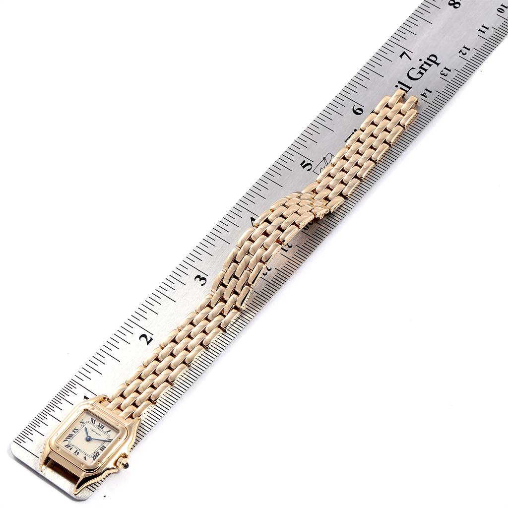 The image shows the Cartier Panthere W25022B9 Women's Yellow Gold Silver Dial W25022B9 Women's Yellow Gold Silver Dial model watch placed next to a ruler, displaying its length and gold bracelet.