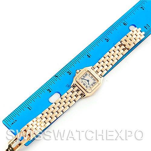 The Cartier Panthere W25022B9 Women
s Yellow Gold Silver Dial W25022B9 Women
s Yellow Gold Silver Dial watch is laid flat next to a ruler, showing its rectangular face and linked bracelet.