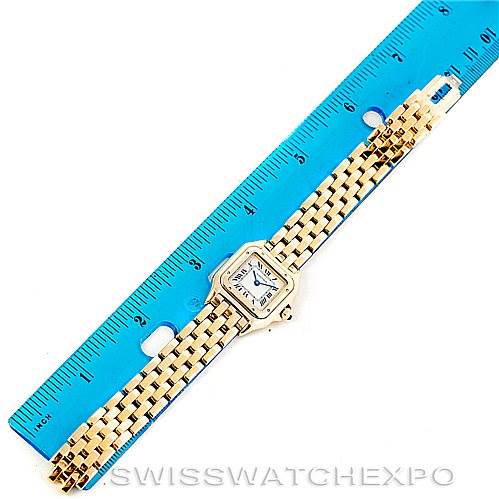 This image shows an overhead view of a Cartier Panthere W25022B9 Women's Yellow Gold Silver Dial W25022B9 Women's Yellow Gold Silver Dial watch, including its face and bracelet, alongside a blue ruler for scale.