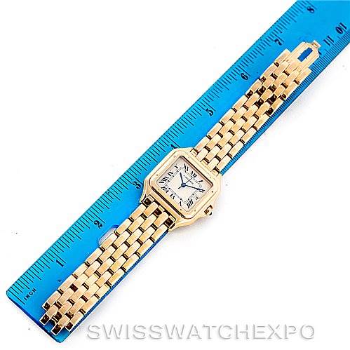 The image shows a top-down angle of a Cartier Panthere W25014B9 Men
s Yellow Gold Silver Dial W25014B9 Men
s Yellow Gold Silver Dial watch, including the face and full length of the bracelet beside a blue ruler.