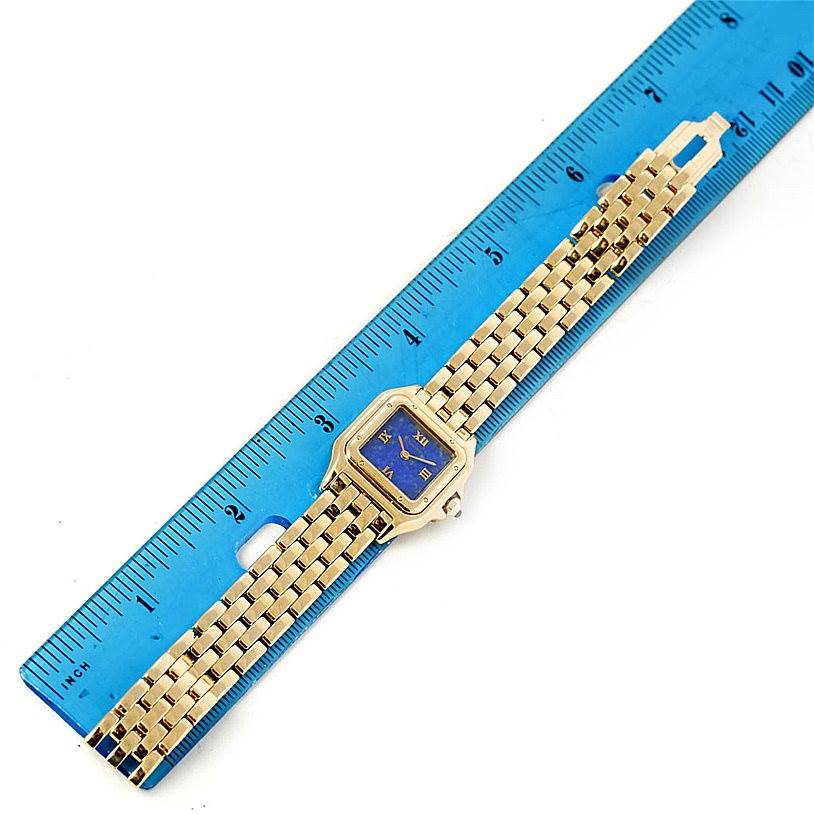 The Cartier Panthere W25022B9 Women's Yellow Gold Blue Dial W25022B9 Women's Yellow Gold Blue Dial watch is shown from a top-down angle, lying flat next to a blue ruler.