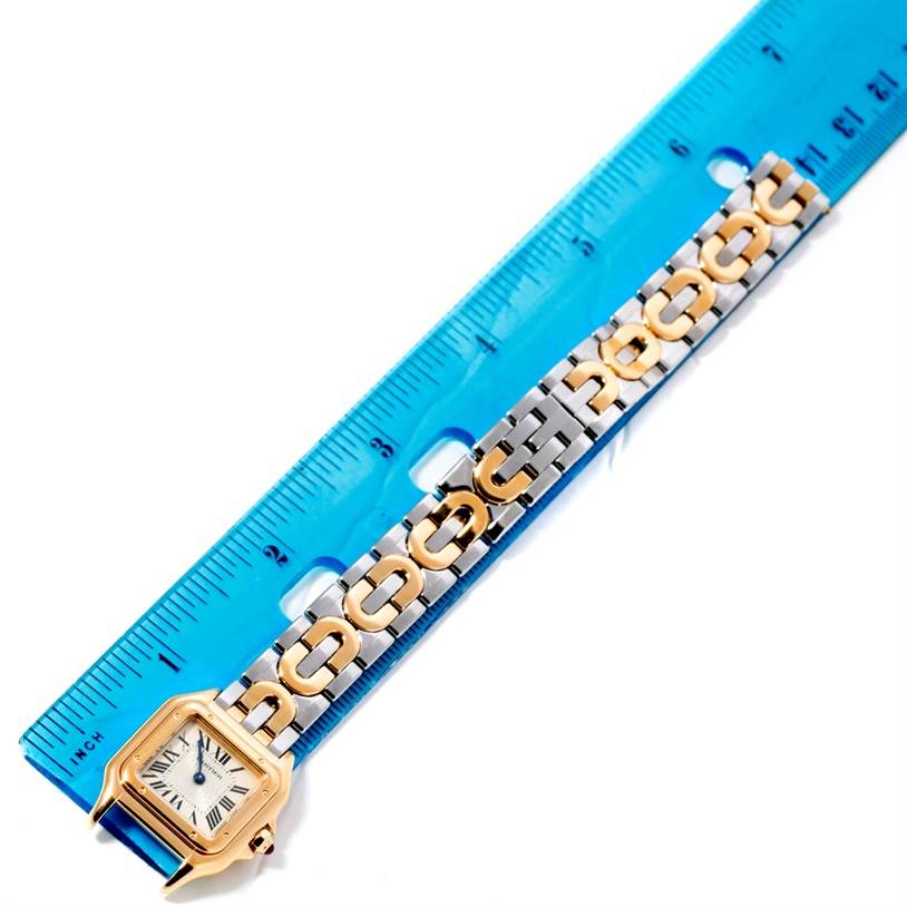 The image shows the Cartier Panthere W25046S1 Women's Yellow Gold Silver Dial W25046S1 Women's Yellow Gold Silver Dial watch lying flat next to a blue ruler, showcasing its face and bracelet.