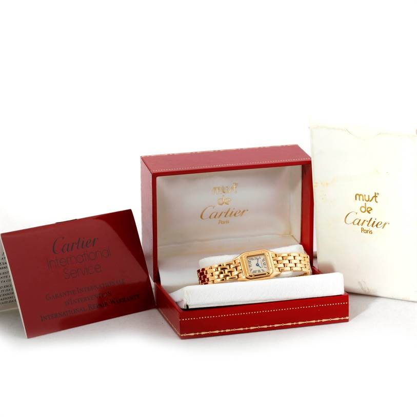 The Panthere model by Cartier is shown in its open box along with the international service booklet on the side.