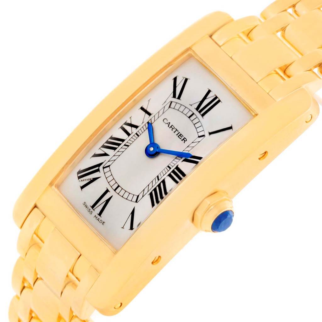 This image shows a Cartier Tank Americaine W26015K2 Women's Yellow Gold Silver Dial W26015K2 Women's Yellow Gold Silver Dial watch at a slight angle, highlighting the gold case, blue hands, and Roman numeral dial.