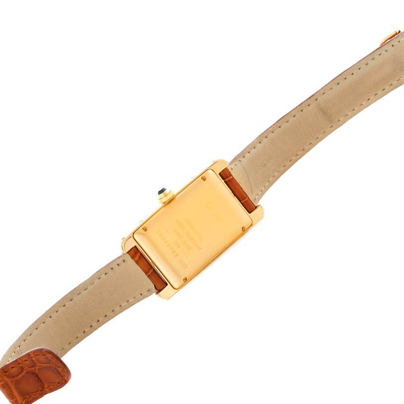 The image shows the back case and leather strap of a Cartier Tank Americaine W2603556 Women's Yellow Gold Silver Dial W2603556 Women's Yellow Gold Silver Dial watch from a top-down angle.