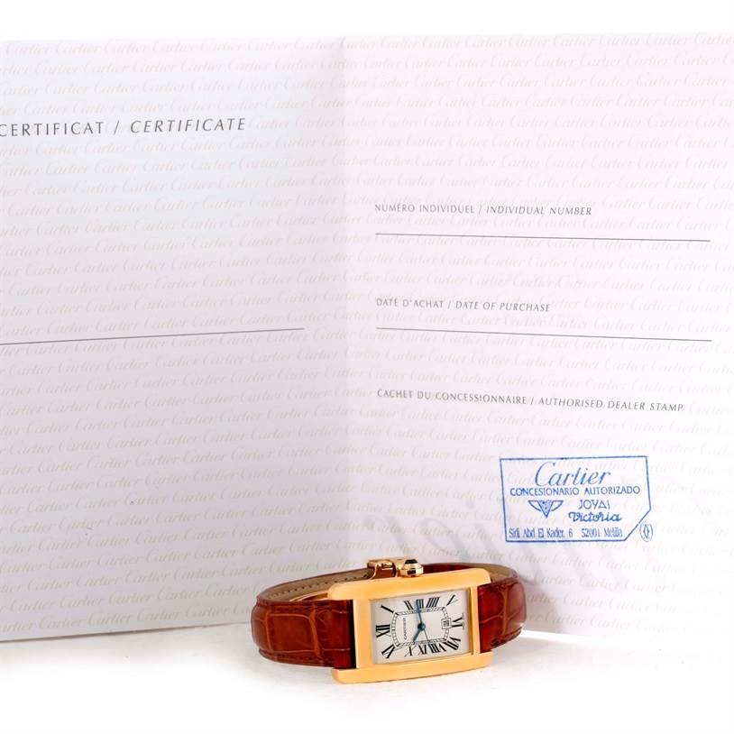 The Cartier Tank Americaine W2603556 Women's Yellow Gold Silver Dial W2603556 Women's Yellow Gold Silver Dial watch is shown lying flat with its face visible, alongside its certificate documentation.