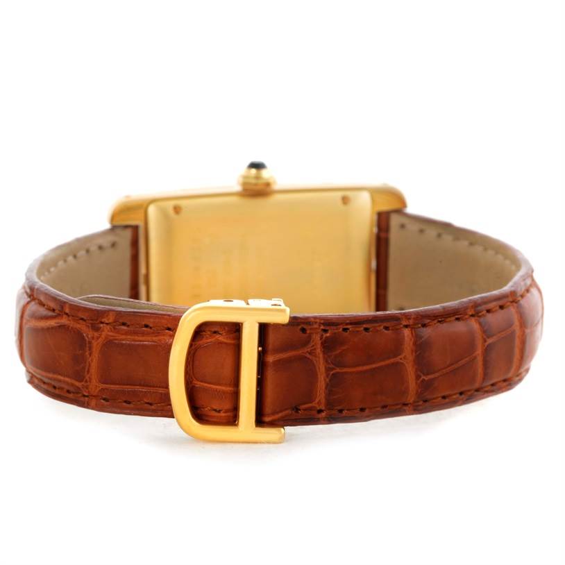 The image shows the back view of a Cartier Tank Americaine W2603556 Women's Yellow Gold Silver Dial W2603556 Women's Yellow Gold Silver Dial watch, highlighting its brown leather strap and gold buckle.