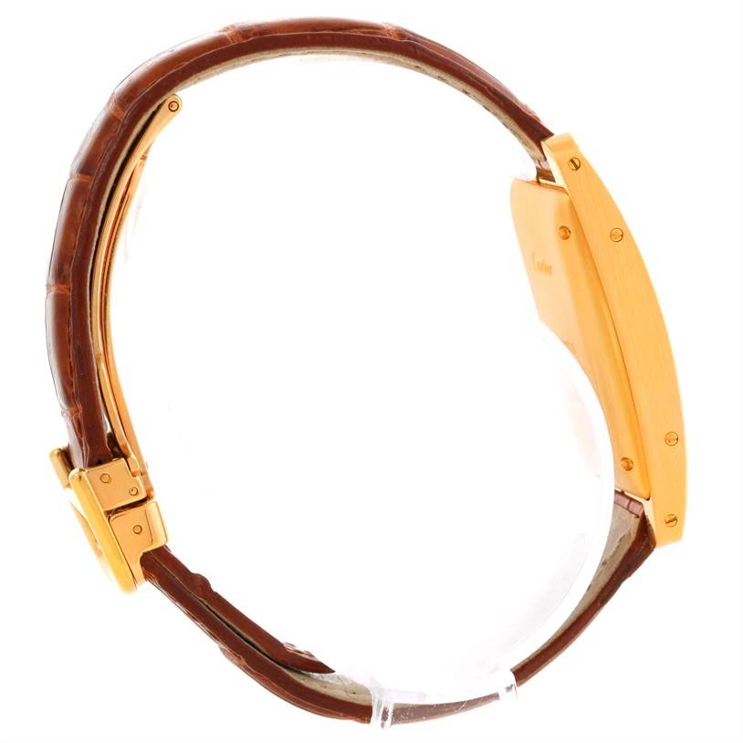 This is a side view of a Cartier Tank Americaine W2603556 Women's Yellow Gold Silver Dial W2603556 Women's Yellow Gold Silver Dial watch, showing its leather strap and gold case.