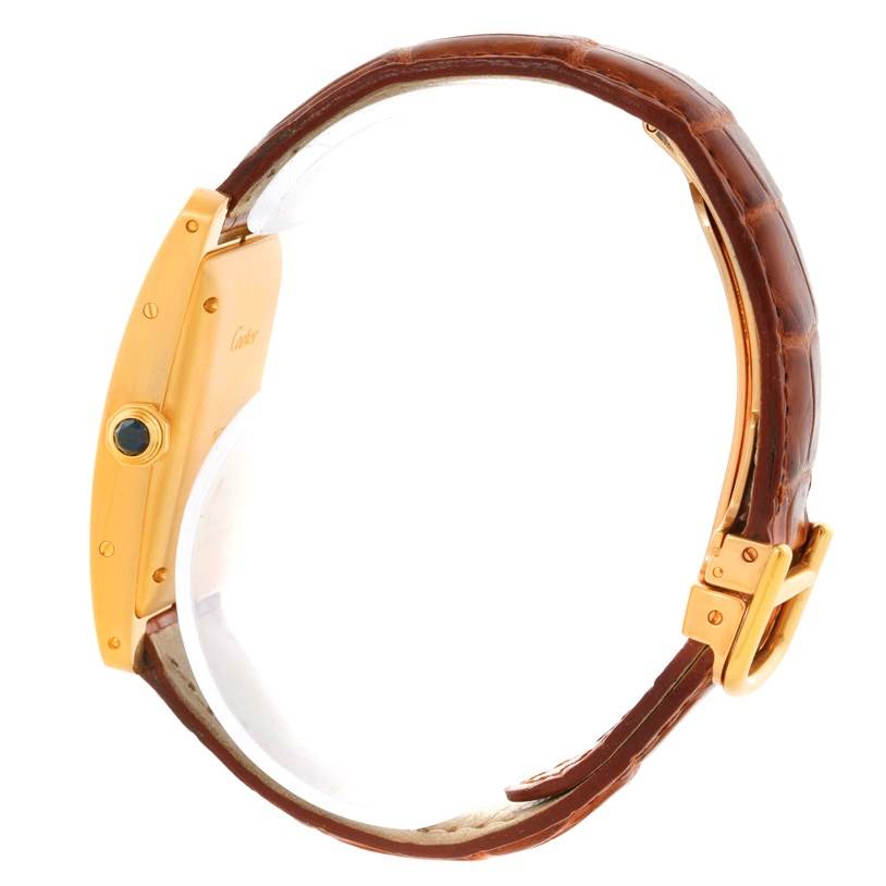 The image shows a side view of a Cartier Tank Americaine W2603556 Women's Yellow Gold Silver Dial W2603556 Women's Yellow Gold Silver Dial watch, highlighting its case, crown, and leather strap.