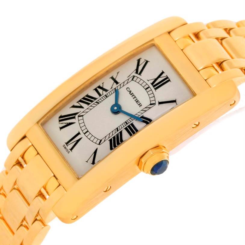 The image shows a Cartier Tank Americaine W26015K2 Women's Yellow Gold Silver Dial W26015K2 Women's Yellow Gold Silver Dial watch at a slight angle, highlighting the face, Roman numerals, and gold bracelet.