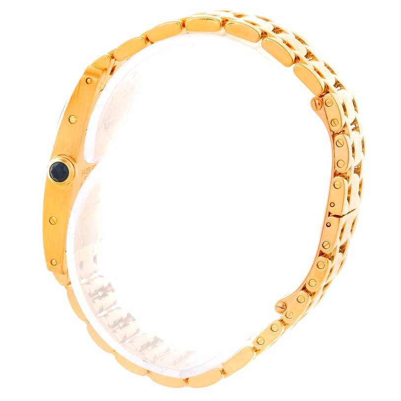 The image shows a side profile view of a Cartier Tank Americaine W26015K2 Women's Yellow Gold Silver Dial W26015K2 Women's Yellow Gold Silver Dial watch, focusing on its gold bracelet and crown.