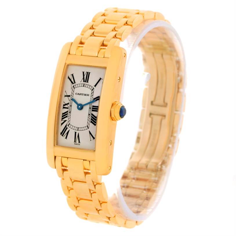 The Cartier Tank Américaine watch is shown at a three-quarter angle, displaying its gold case, white dial, Roman numerals, and gold bracelet.