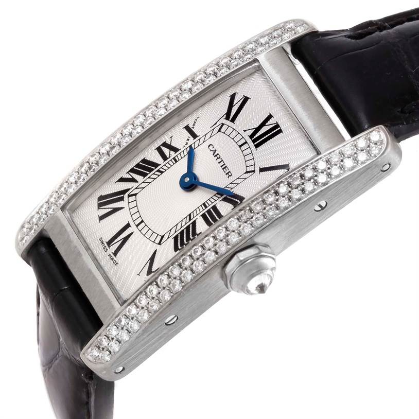 The image shows a close-up of a Cartier Tank Americaine WB701851 Men's White Gold Silver Dial WB701851 Men's White Gold Silver Dial watch, highlighting its diamond-set bezel, dial, and part of the strap.