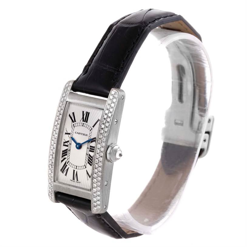 The image shows the Cartier Tank Americaine WB701851 Men's White Gold Silver Dial WB701851 Men's White Gold Silver Dial watch at a three-quarter angle, highlighting the face, strap, and diamond-encrusted bezel.