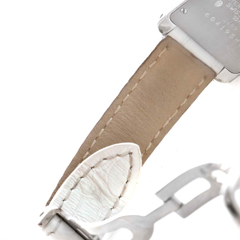 The image shows the back of a Cartier Tank Americaine WB701851 Women
s White Gold Silver Dial WB701851 Women
s White Gold Silver Dial watch with part of the leather strap and metal clasp visible.