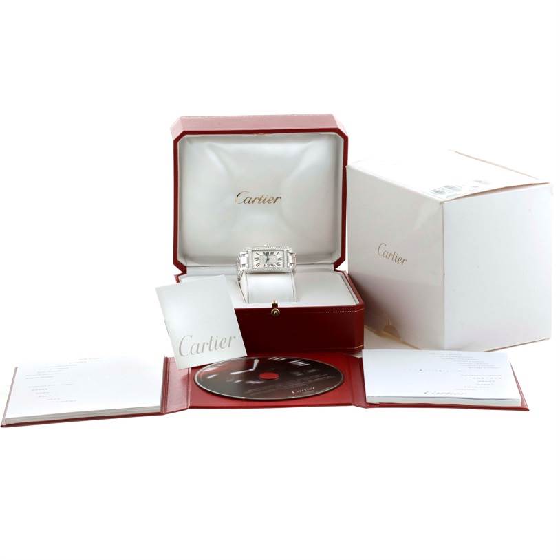 The Cartier Tank Americaine WB710001 Women
s White Gold Silver Dial WB710001 Women
s White Gold Silver Dial watch is shown from the front, nestled in its open box, with accompanying accessories including booklets and a CD.