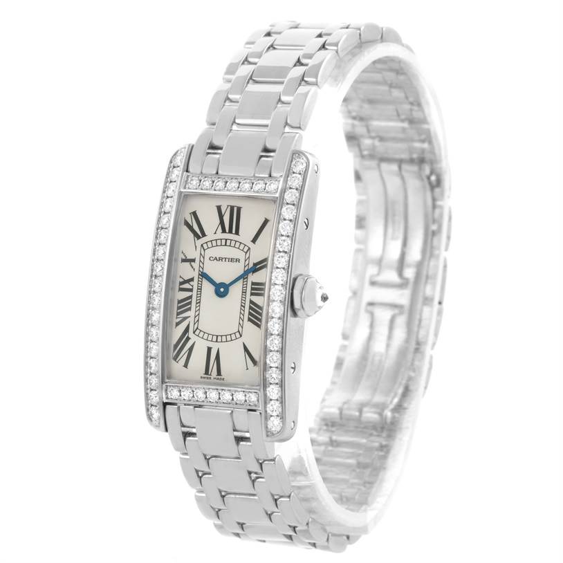 The image shows the Cartier Tank Americaine WB7073L1 Women's White Gold Silver Dial WB7073L1 Women's White Gold Silver Dial watch at an angle highlighting the face, bezel, crown, and part of the metal bracelet.