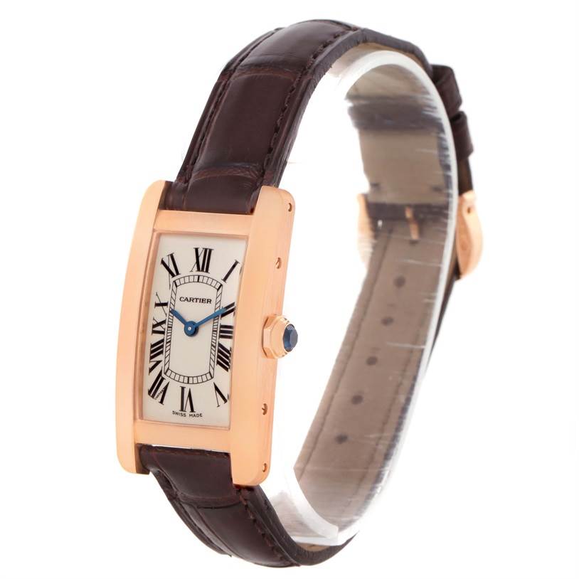 This image shows a Cartier Tank Americaine W2607456 Women's Rose Gold Silver Dial W2607456 Women's Rose Gold Silver Dial watch at an angle highlighting its face, crown, and leather strap.