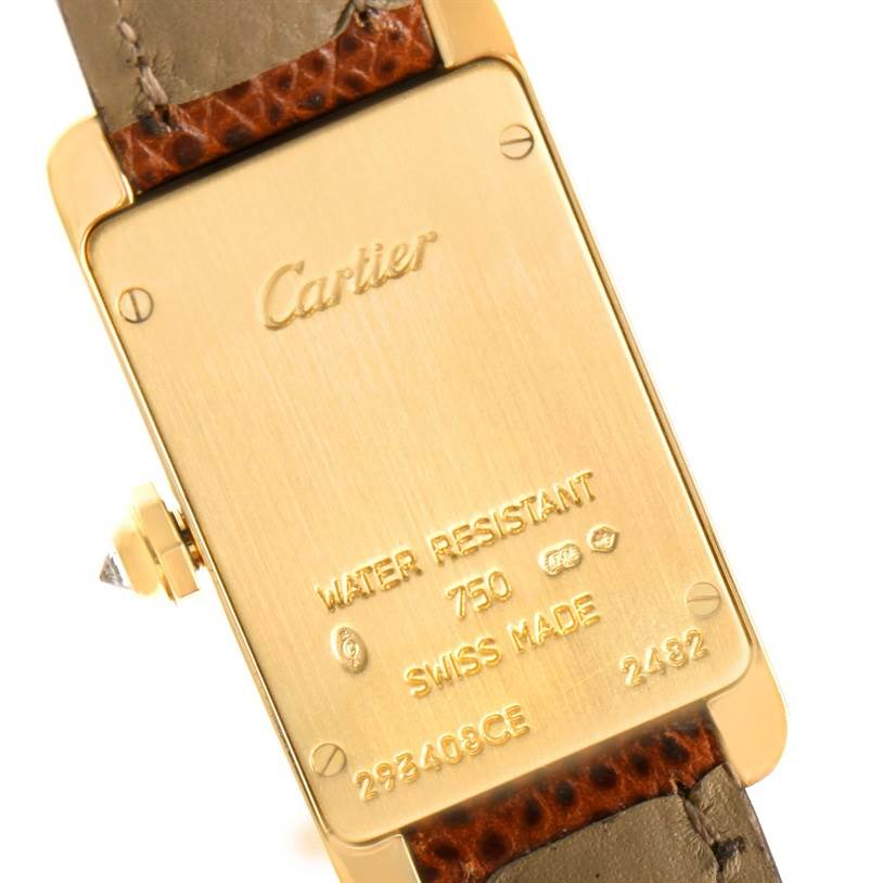 The image shows the back of a Cartier Tank Americaine WB707231 Women
s Yellow Gold Silver Dial WB707231 Women
s Yellow Gold Silver Dial watch, highlighting its water-resistant feature and other engravings.