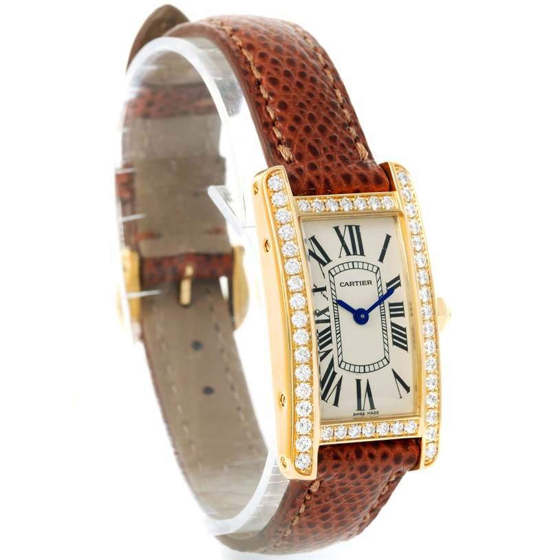 The Cartier Tank Américaine watch is shown at an angled view, highlighting its diamond bezel, brown leather strap, and Roman numerals.