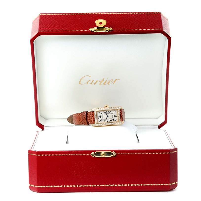 The Cartier Tank Americaine WB707231 Women
s Yellow Gold Silver Dial WB707231 Women
s Yellow Gold Silver Dial watch is shown from the front, displayed in a red jewelry box with a white interior.