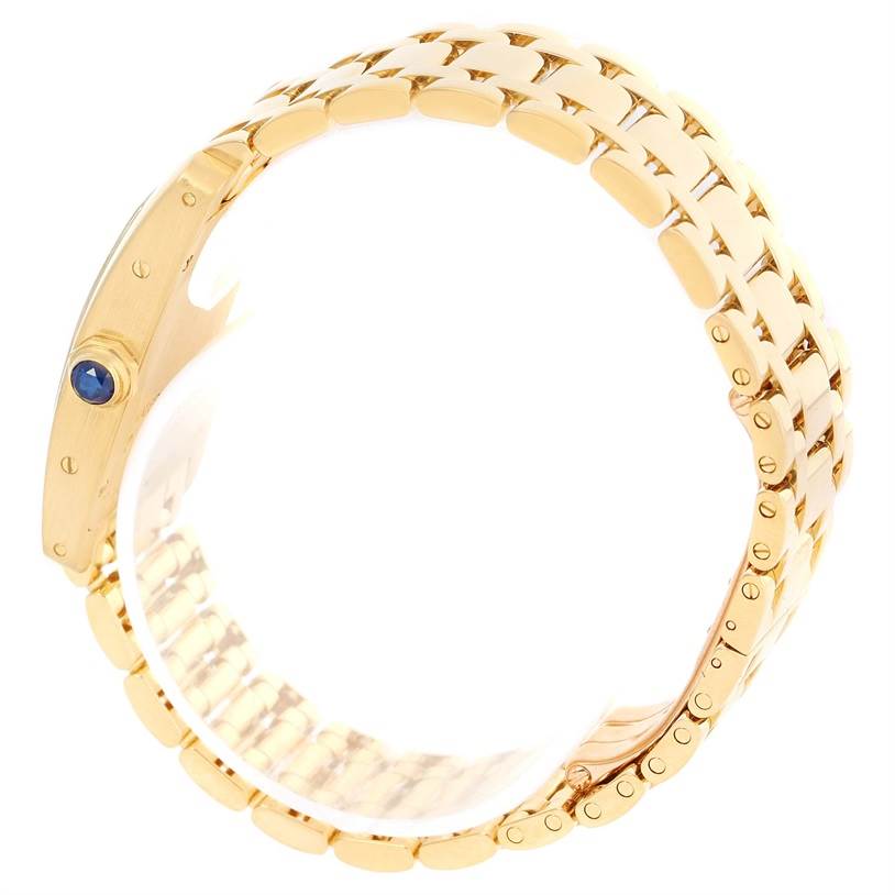The image shows a side view of a gold bracelet and the crown with a blue cabochon of the Cartier Tank Americaine W26015K2 Women's Yellow Gold Silver Dial W26015K2 Women's Yellow Gold Silver Dial watch.