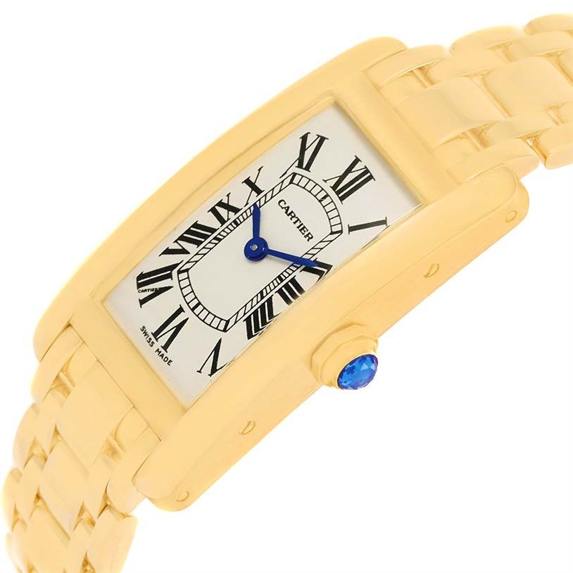 This image shows a tilted view of the Cartier Tank Americaine W26015K2 Women's Yellow Gold Silver Dial W26015K2 Women's Yellow Gold Silver Dial watch, highlighting its face, Roman numerals, blue hands, and gold bracelet.