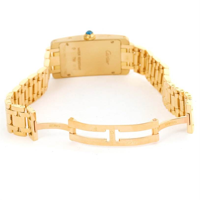 This image shows the back view of a Tank Americaine watch by Cartier, highlighting its gold bracelet and clasp.