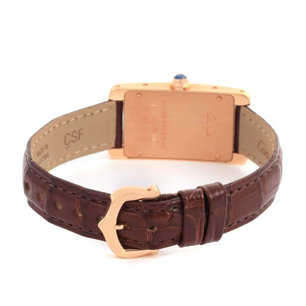 This image shows the underside of a Cartier Tank Americaine W2607456 Women
s Rose Gold Silver Dial W2607456 Women
s Rose Gold Silver Dial watch, highlighting the back case, leather strap, and clasp.