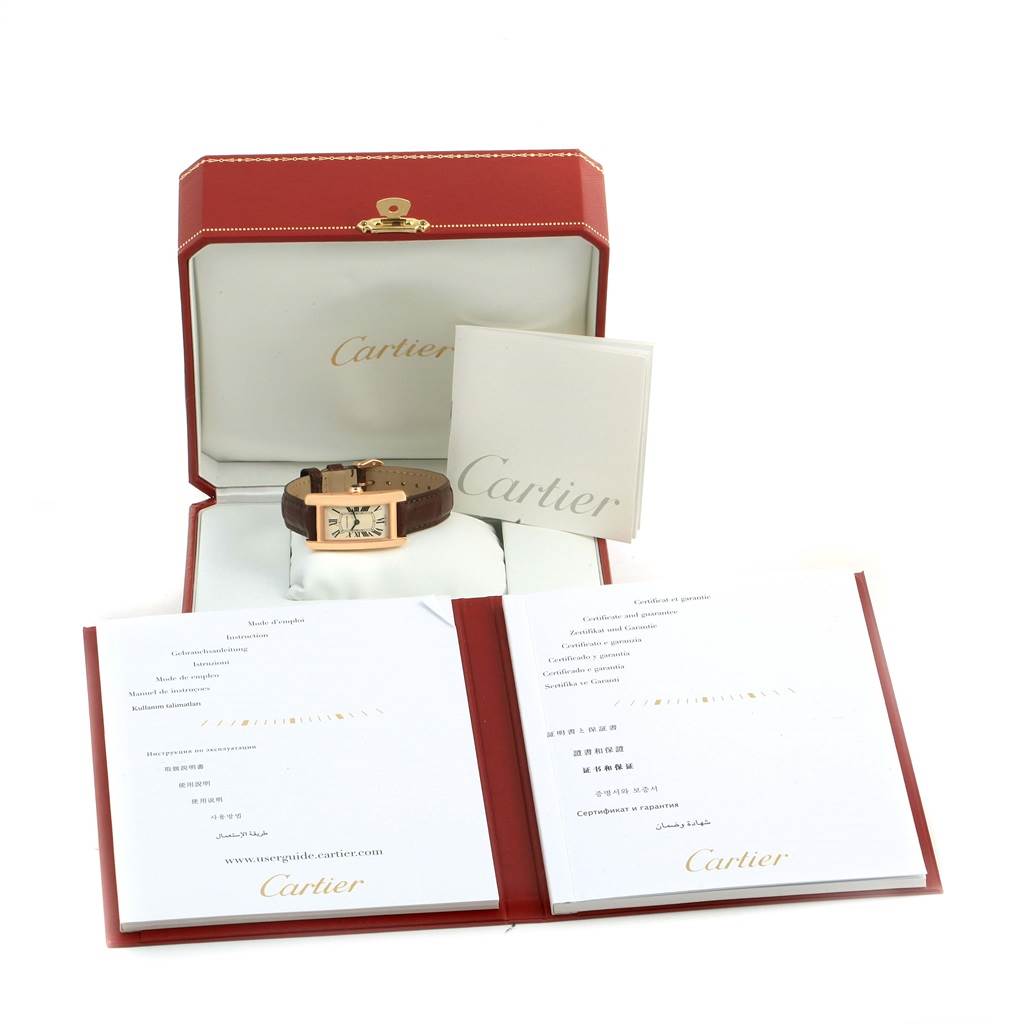 The Cartier Tank Americaine W2607456 Women
s Rose Gold Silver Dial W2607456 Women
s Rose Gold Silver Dial watch is shown in its open box, accompanied by booklets and documents.