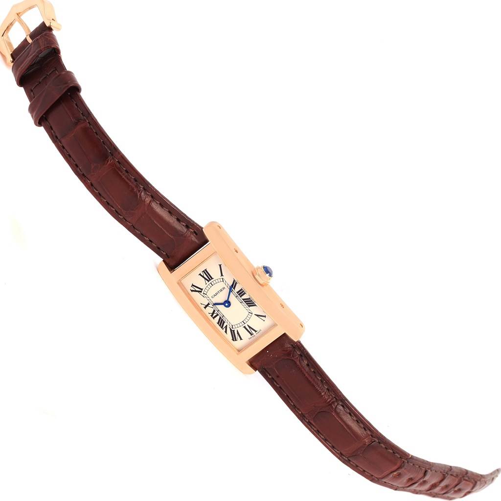 The image shows a top view of the Cartier Tank Américaine watch, highlighting the rectangular dial, leather strap, and crown.