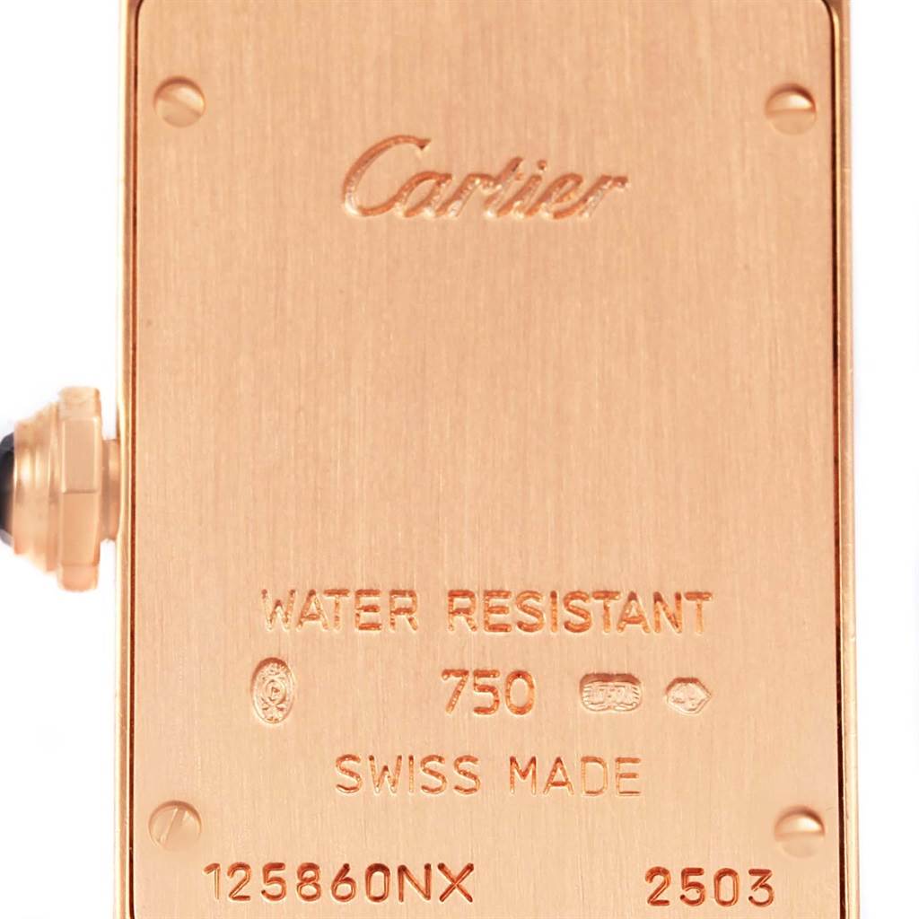 This is a close-up of the back of a Tank Américaine Cartier watch, showing its engravings and crown.