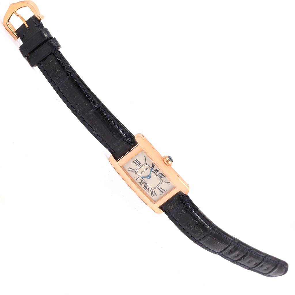 The image shows a Cartier Tank Americaine W2607456 Women
s Rose Gold Silver Dial W2607456 Women
s Rose Gold Silver Dial watch with a rectangular case, black leather strap, and visible face including Roman numerals.