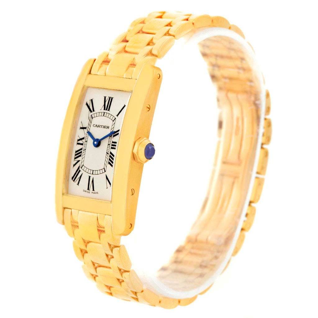 The Cartier Tank Américaine watch is shown at a slight angle, displaying its gold bracelet, rectangular case, dial, and crown.