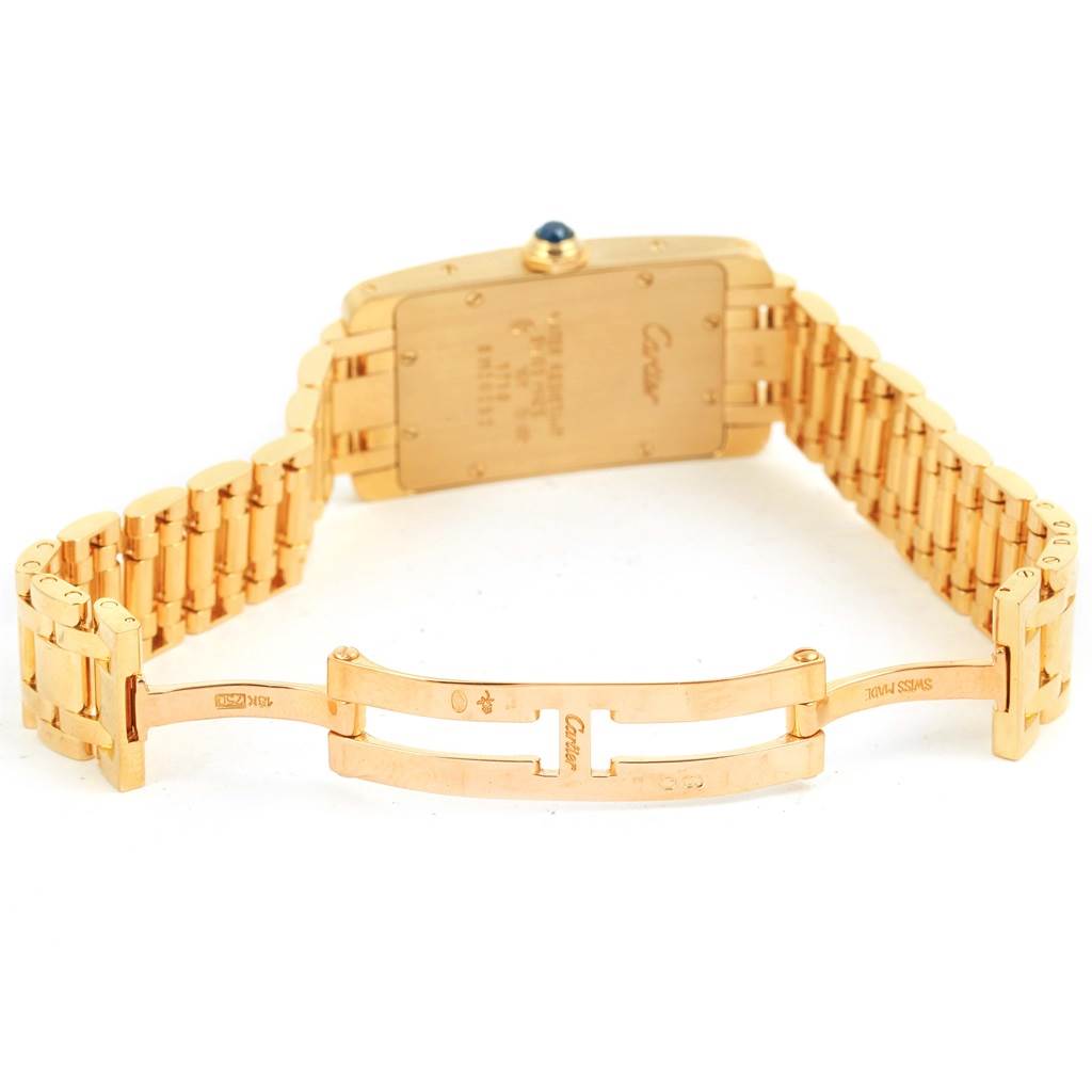 The image shows the back view of the Cartier Tank Americaine W26015K2 Women
s Yellow Gold Silver Dial W26015K2 Women
s Yellow Gold Silver Dial watch, highlighting the case back and part of the bracelet.