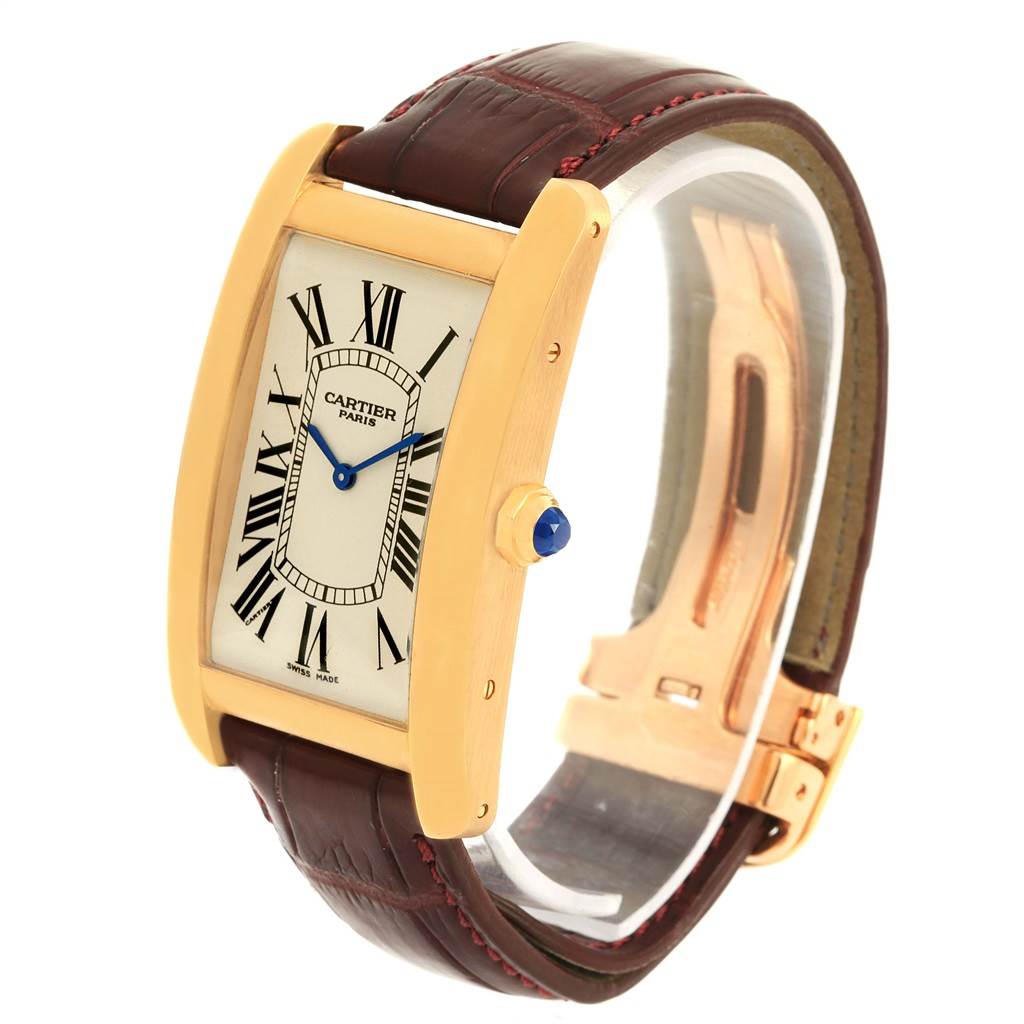 The image shows a Cartier Tank Americaine 1735 Men
s Yellow Gold Silver Dial 1735 Men
s Yellow Gold Silver Dial watch at a three-quarter angle, highlighting its gold case, Roman numeral dial, and leather strap.