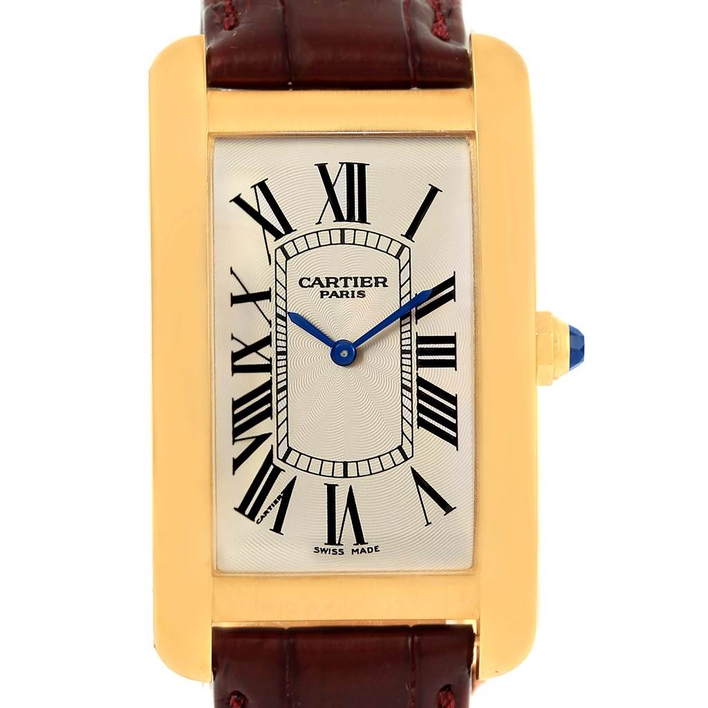 This image shows a frontal view of the Cartier Tank Americaine 1735 Men
s Yellow Gold Silver Dial 1735 Men
s Yellow Gold Silver Dial watch, highlighting its rectangular face, Roman numerals, and leather strap.