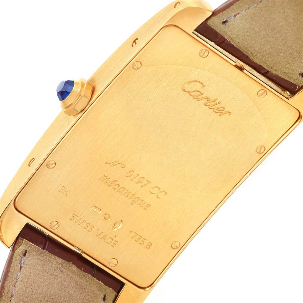 The image shows the back case and part of the strap of the Cartier Tank Americaine 1735 Men
s Yellow Gold Silver Dial 1735 Men
s Yellow Gold Silver Dial watch.