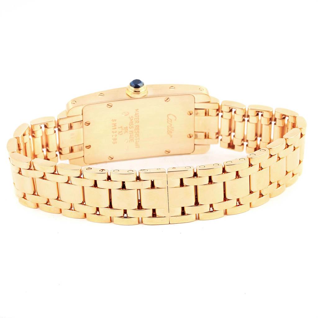 The image shows the back and bracelet of a Cartier Tank Americaine W26015K2 Women's Yellow Gold Silver Dial W26015K2 Women's Yellow Gold Silver Dial watch, highlighting its clasp and engravings.